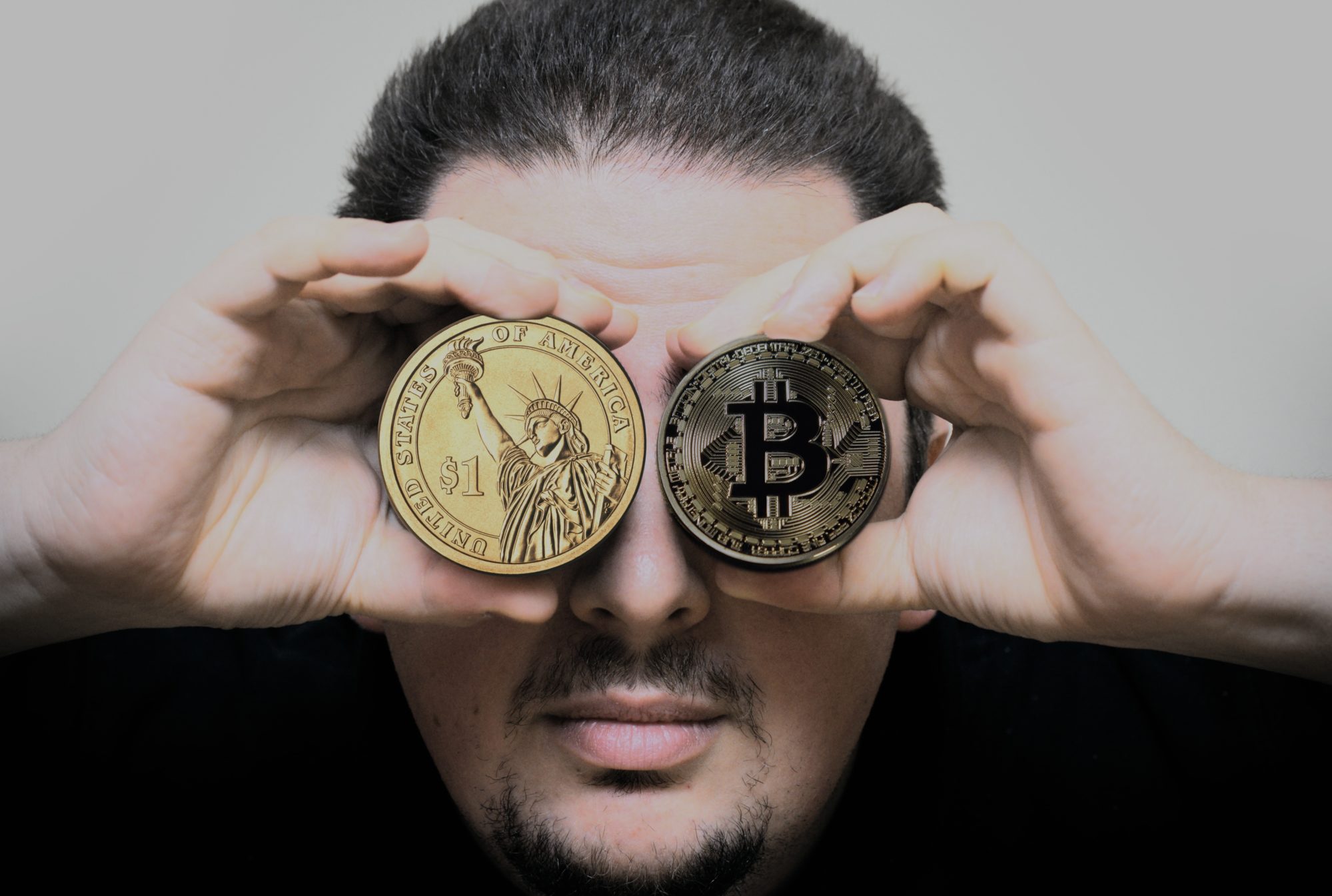 Homme tenant un bitcoin et un dollar pour voir